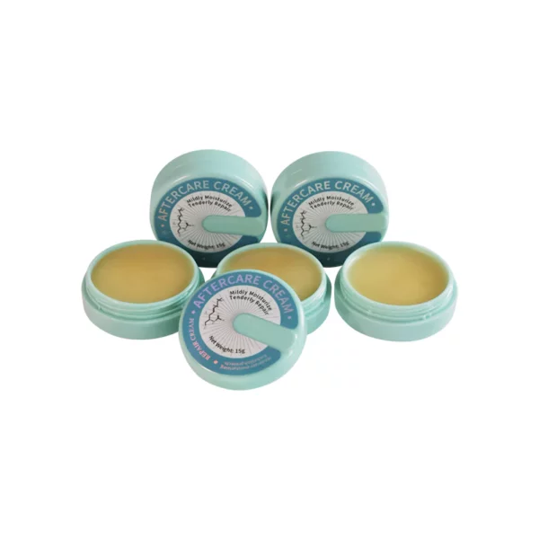 Five open containers of aftercare cream with blue lids.