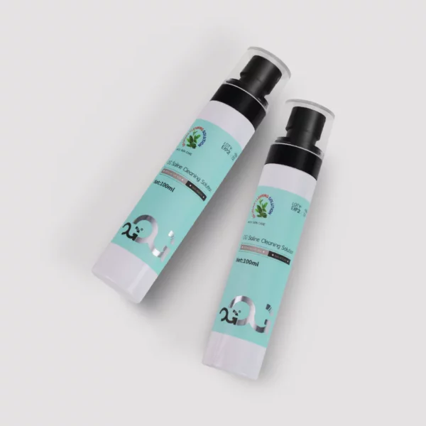 Two bottles of skincare cream with green labels on a gray background.