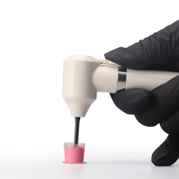 TattooInkMixer04 Gloved hand holding dental tool above pink polishing paste.